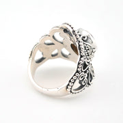 Silver ring with intricate design on a white background