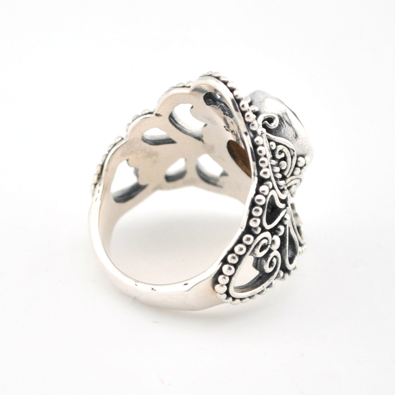 Silver ring with intricate design on a white background