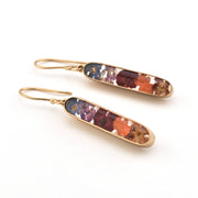 Pair of gold earrings with colorful stones on a white background
