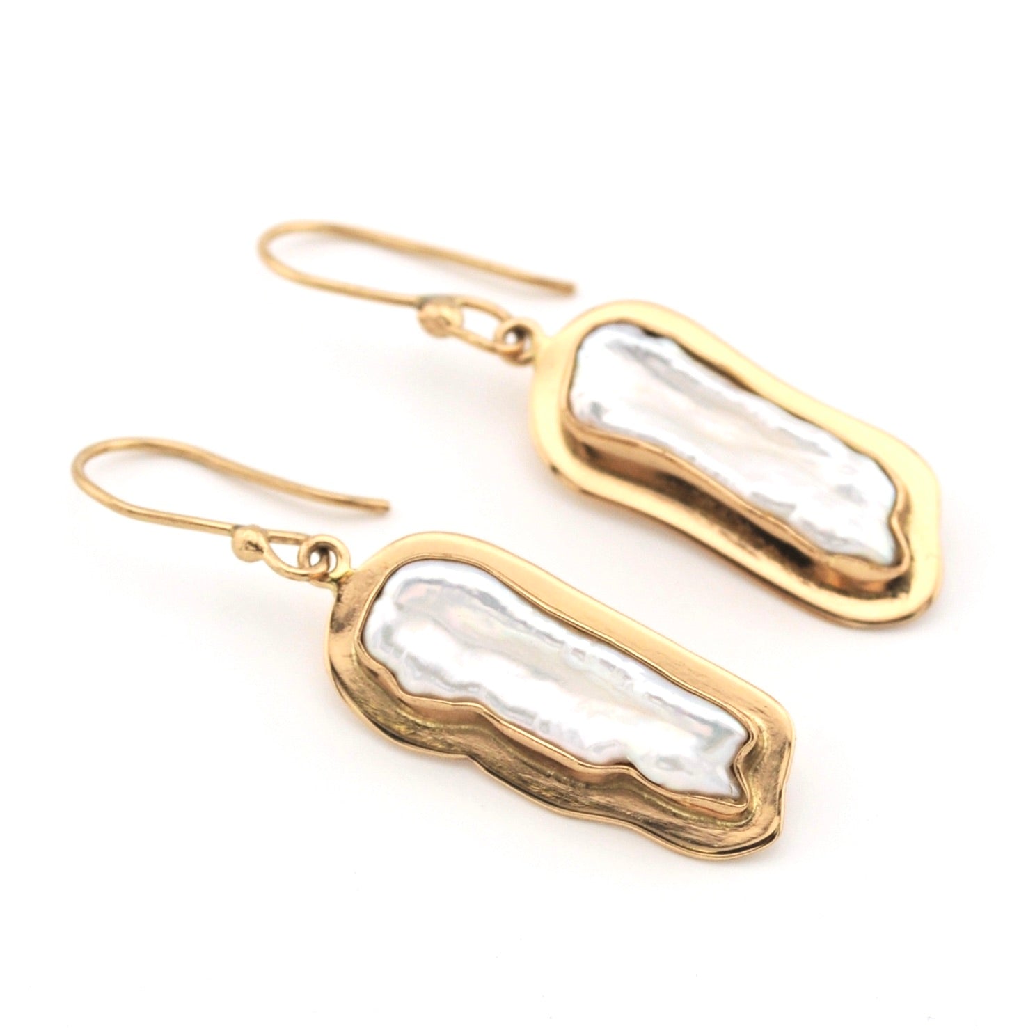 Gold earrings with pearl on a white background