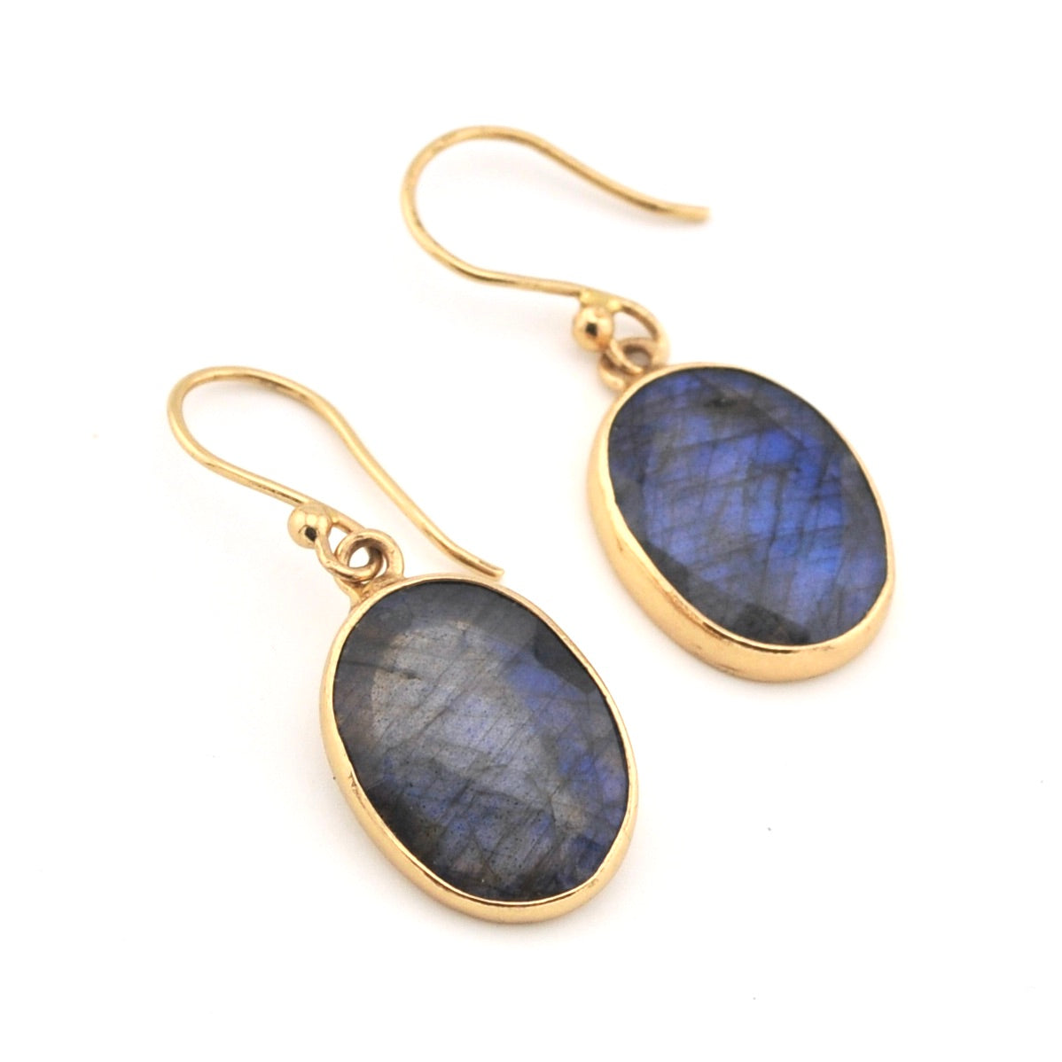 Gold earrings with blue gemstones on a white background
