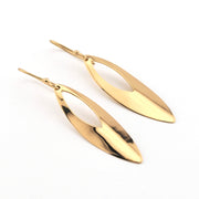 Gold leaf-shaped earrings on a white background