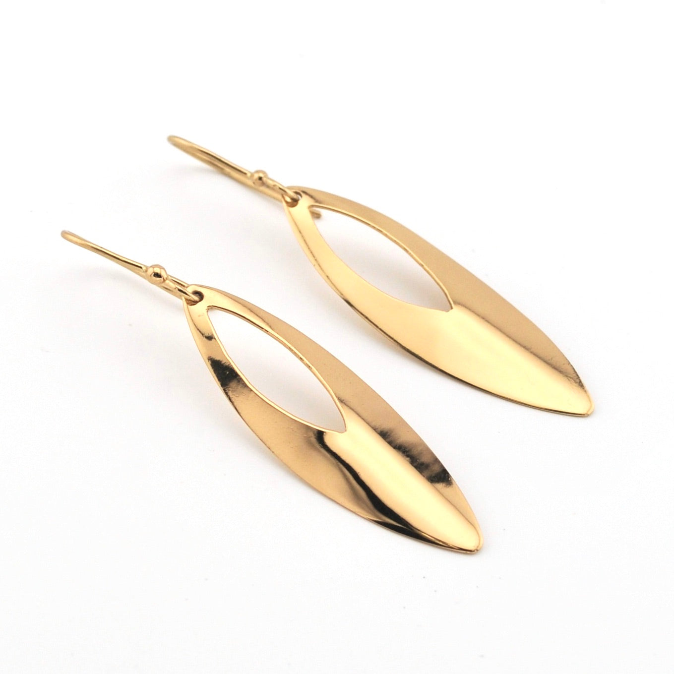 Gold leaf-shaped earrings on a white background