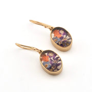 Gold earrings with floral designs on a white background