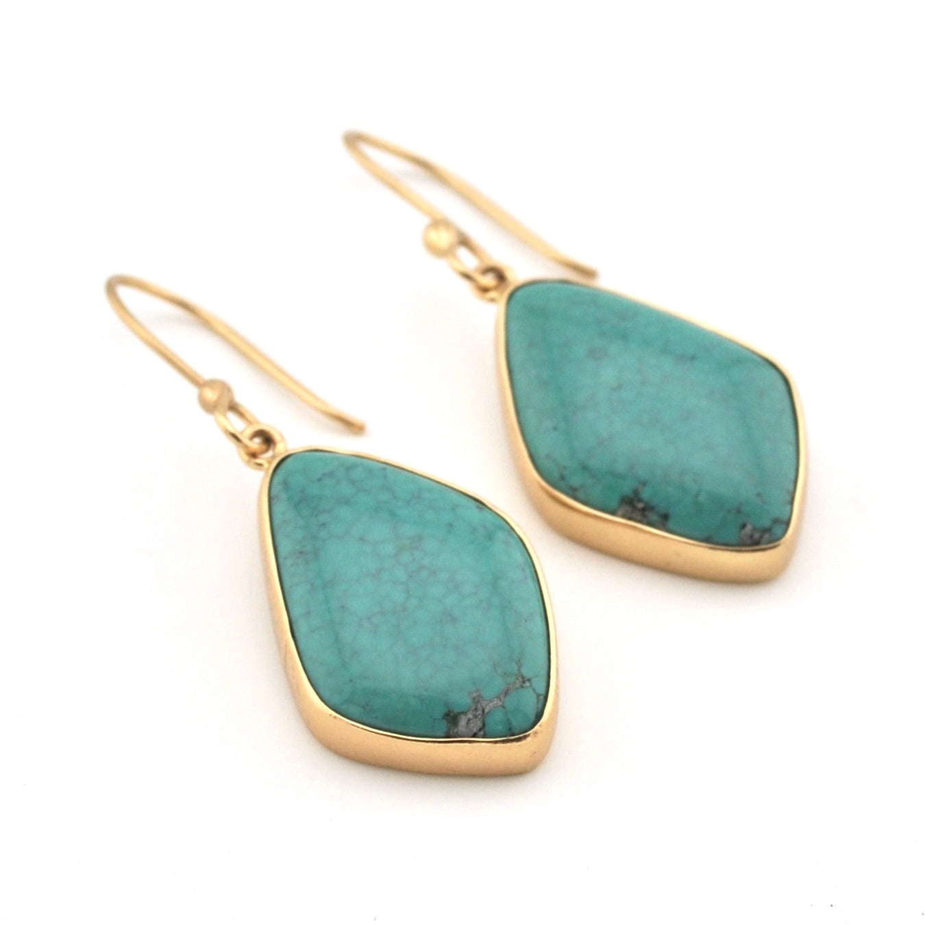 Turquoise earrings with gold frames on a white background