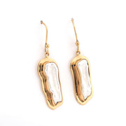 Gold and white earrings on a white background