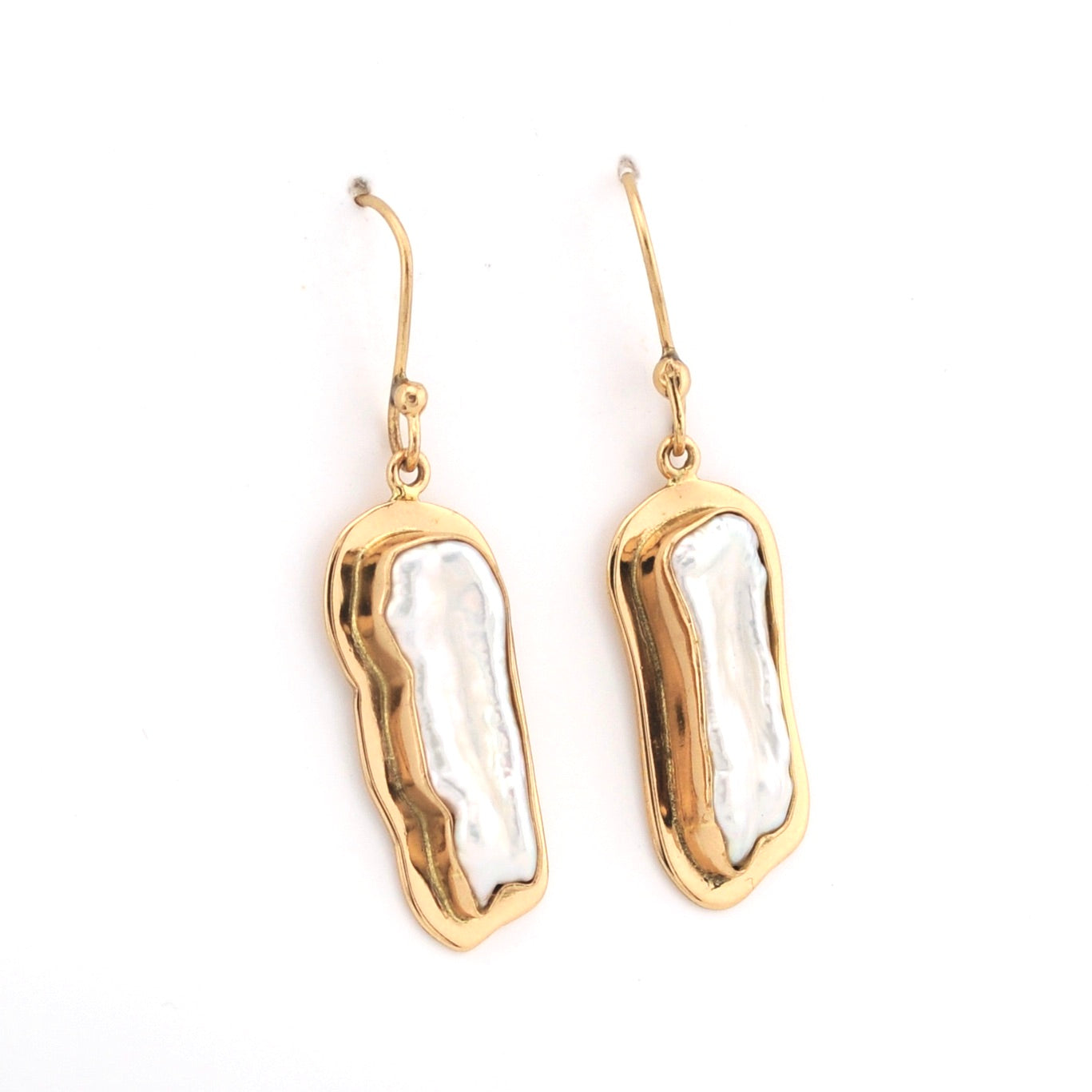 Gold and white earrings on a white background