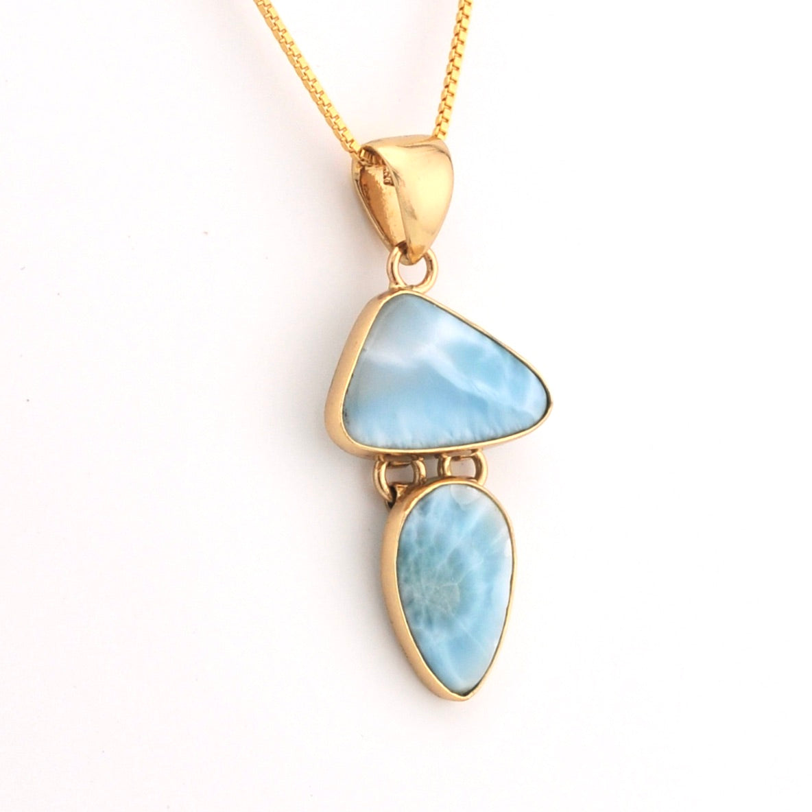 Gold necklace with a pendant featuring two blue stones on a white background