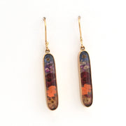 Pair of gold earrings with multicolored stone inlays on a white background