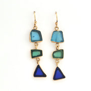 Pair of earrings with blue and green triangular stones on a white background
