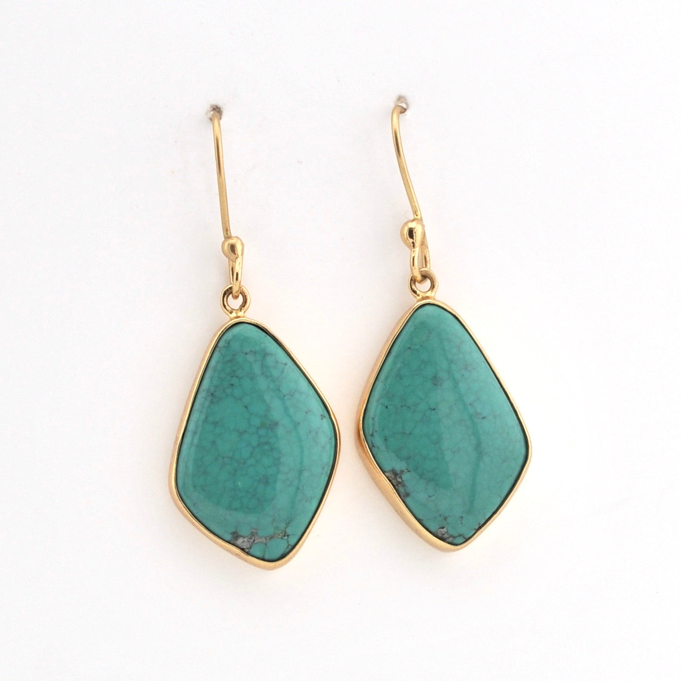 Teal earrings with gold hooks on a white background