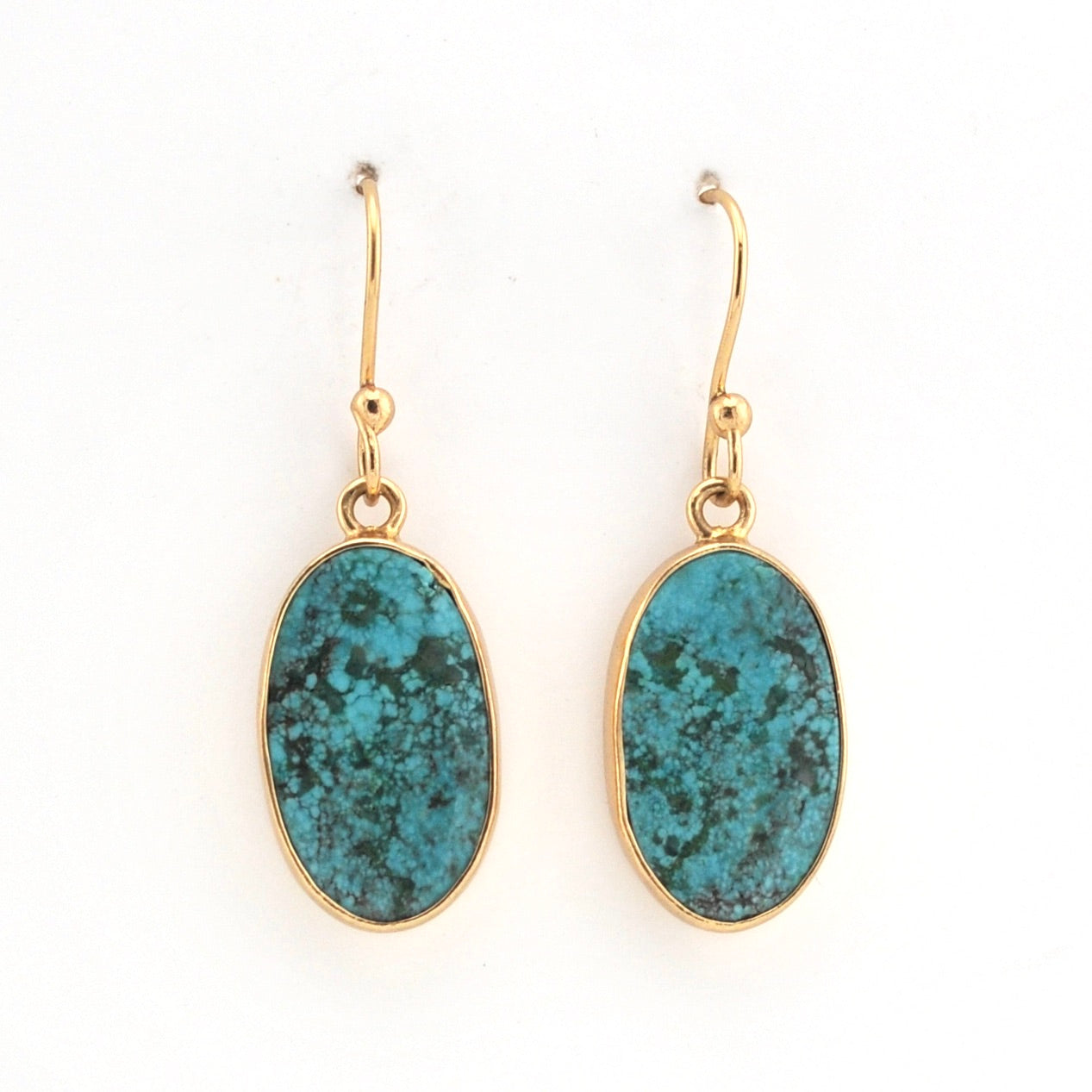 Gold earrings with blue stone on a white background