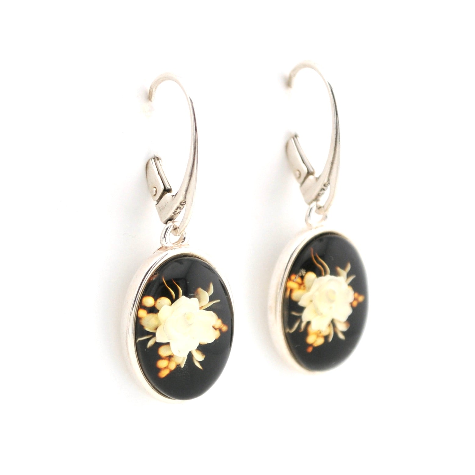 Pair of earrings with black oval stones featuring floral designs on a white background
