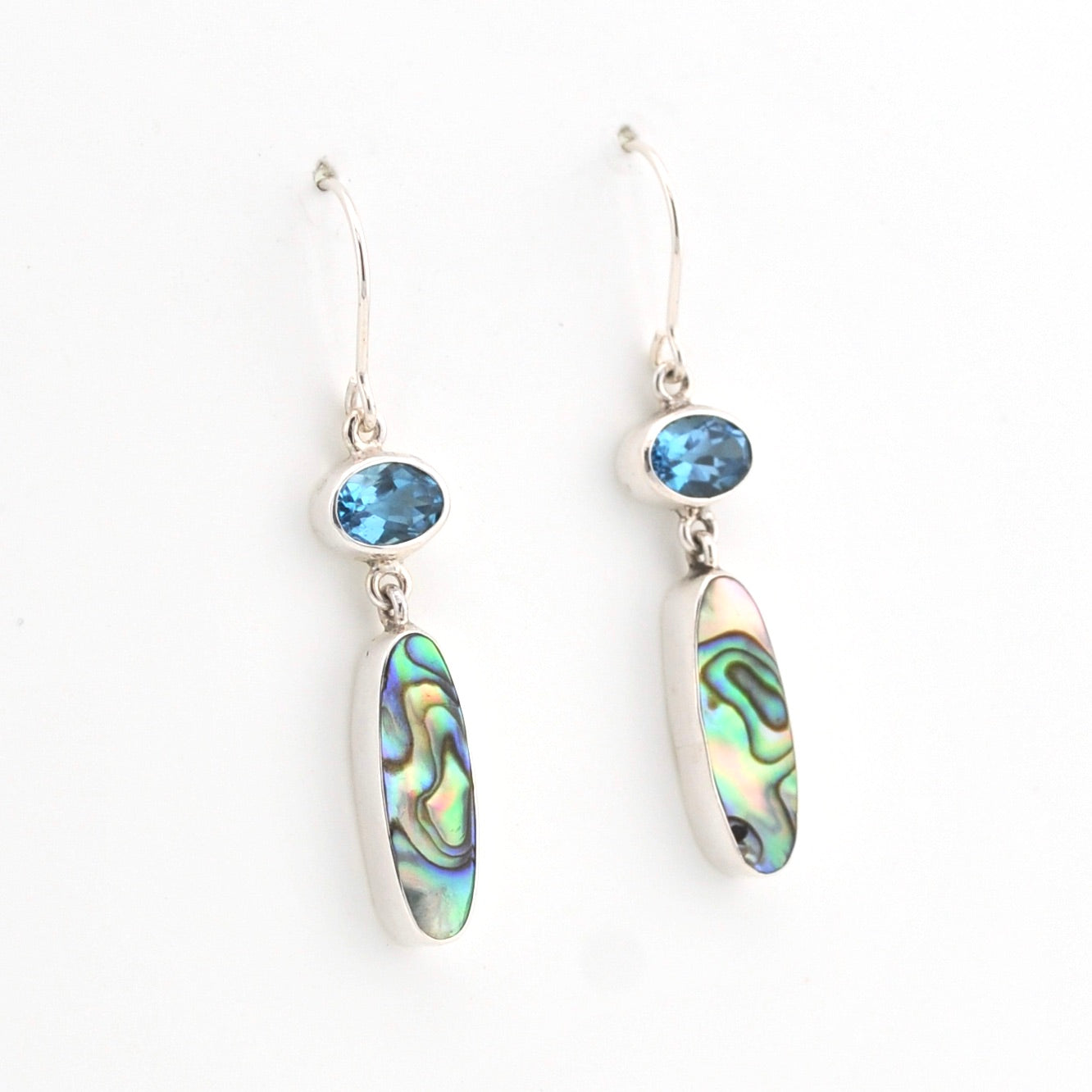 Pair of earrings with abalone shell and blue gemstone on a white background