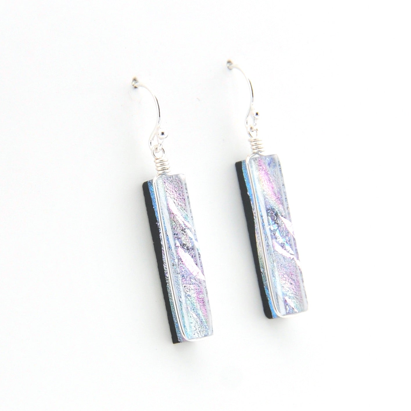 Pair of earrings with rectangular, iridescent glass on a white background