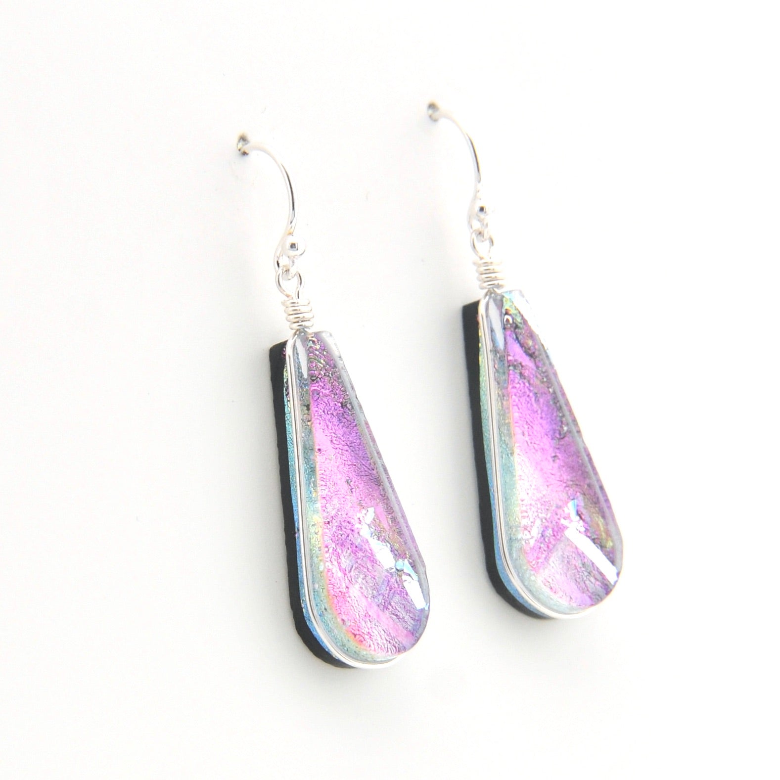 Teardrop-shaped earrings with a pink and purple iridescent finish on a white background