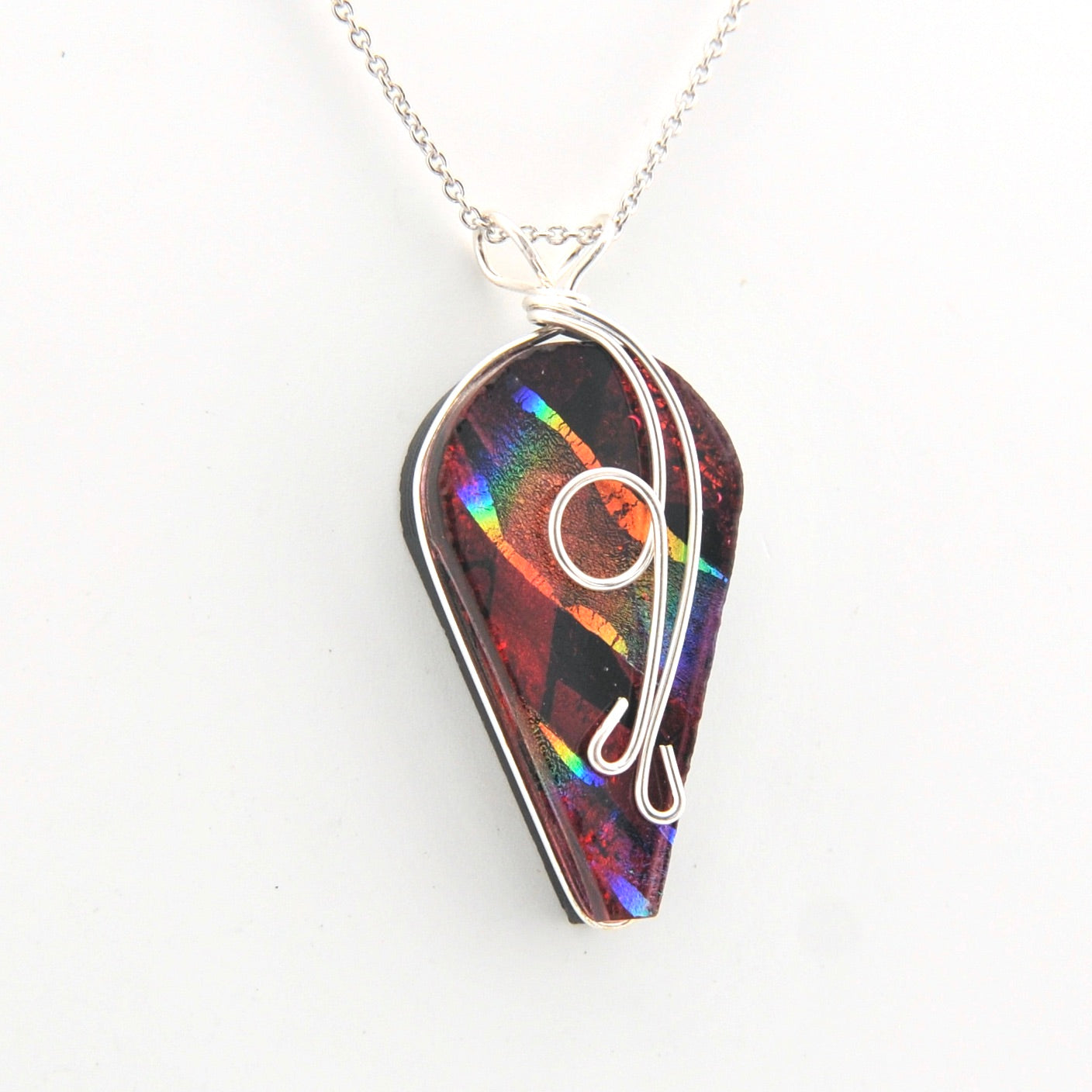 Multicolored pendant with a silver chain on a white background