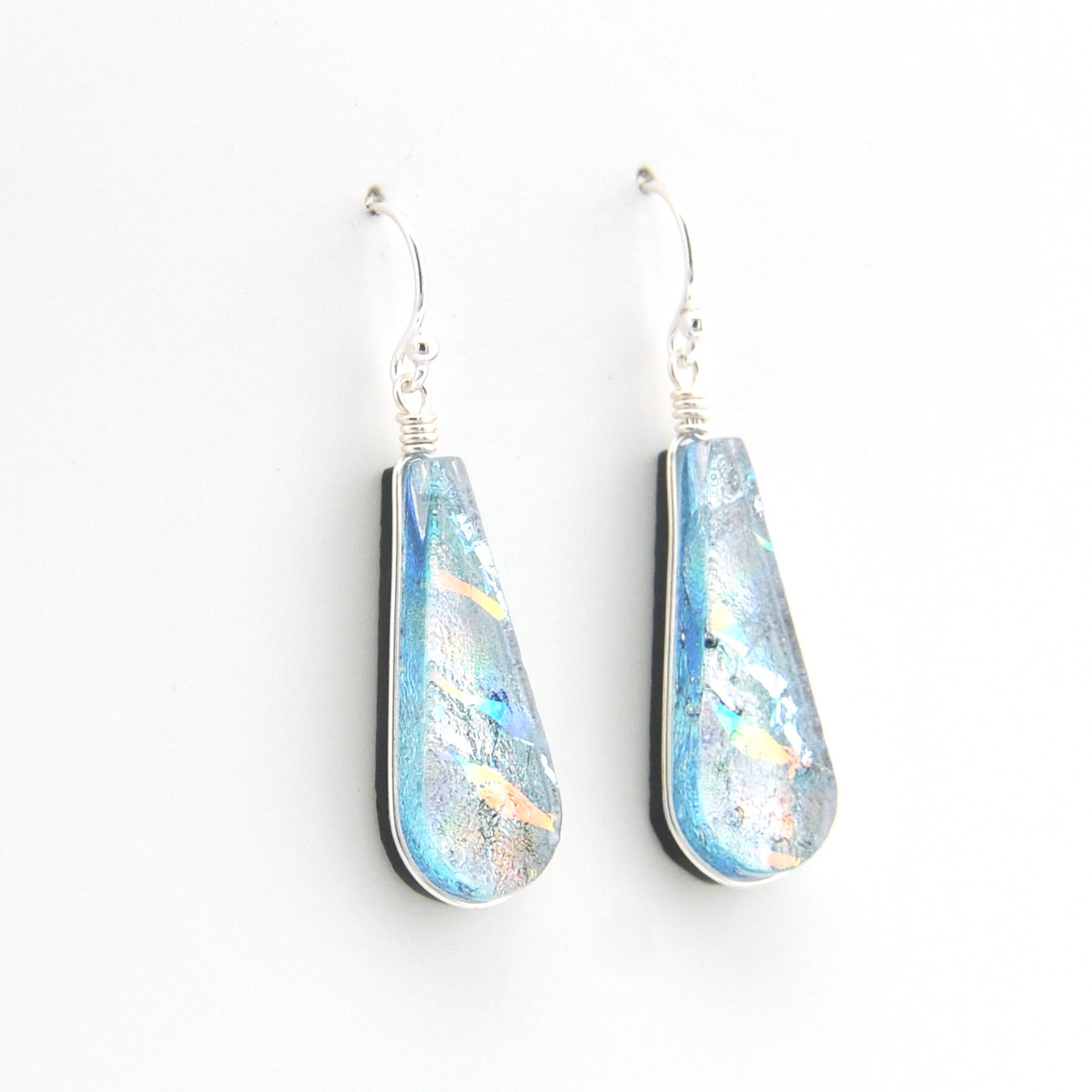 Teardrop-shaped earrings with iridescent finish on a white background