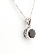 Silver necklace with a garnet pendant on a white background