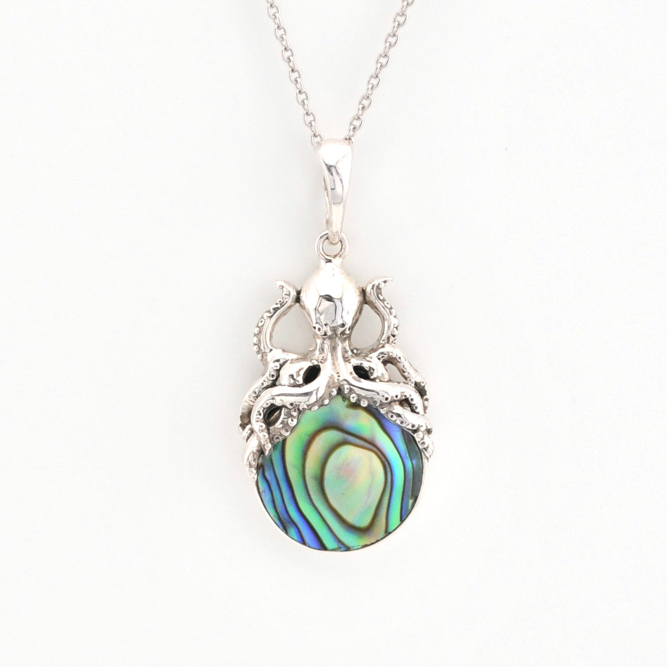 Silver pendant with a colorful central stone on a white background