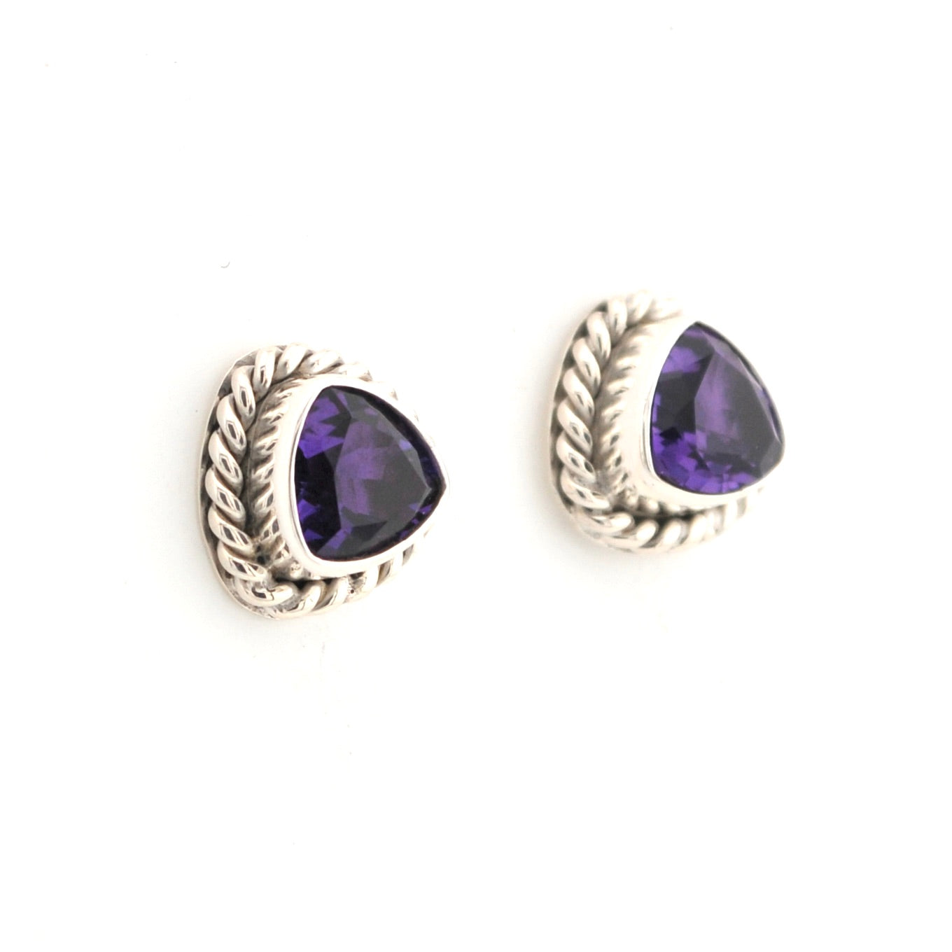 Pair of silver earrings with purple gemstones on a white background