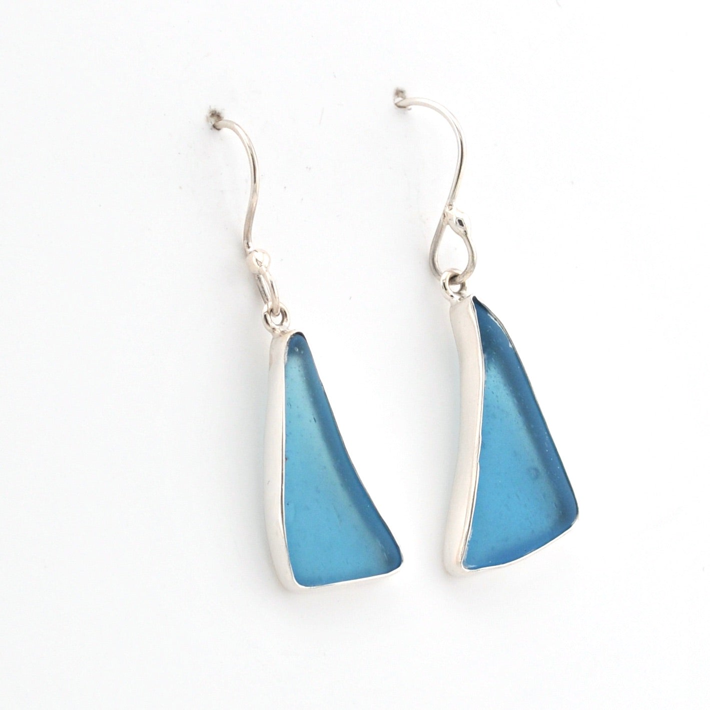 Pair of blue triangular earrings on a white background