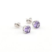 Silver stud earrings with purple gemstones on a white background