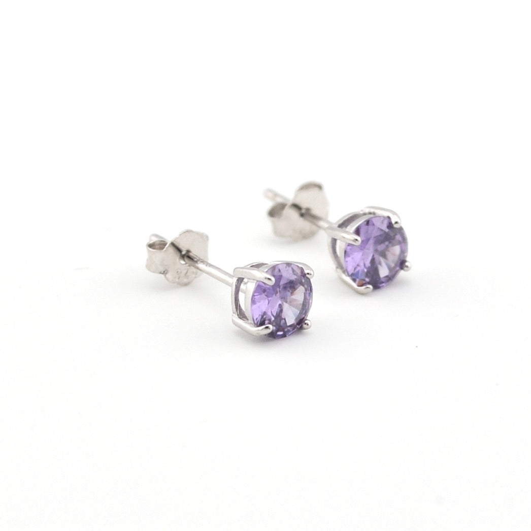 Silver stud earrings with purple gemstones on a white background