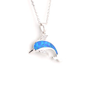 Dolphin-shaped pendant with blue opal and clear stones on a white background