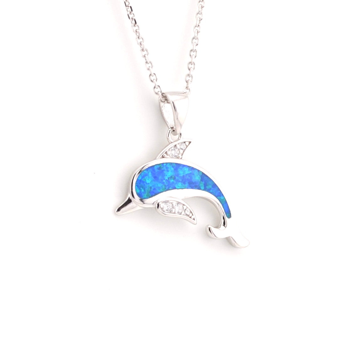 Dolphin-shaped pendant with blue opal and clear stones on a white background