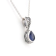 Silver pendant with a blue gemstone on a white background