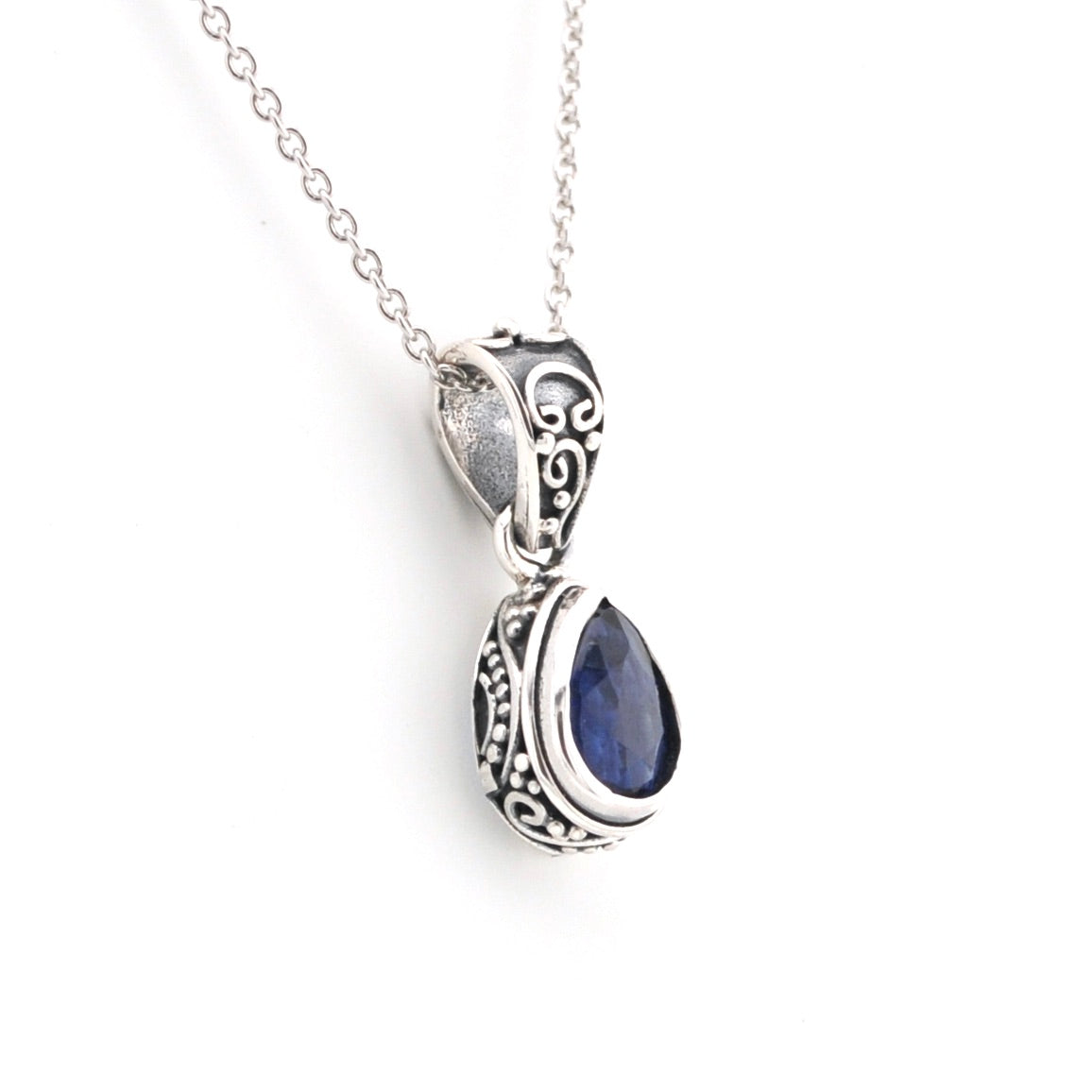 Silver pendant with a blue gemstone on a white background
