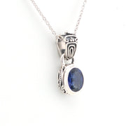 Silver pendant with a blue gemstone on a white background