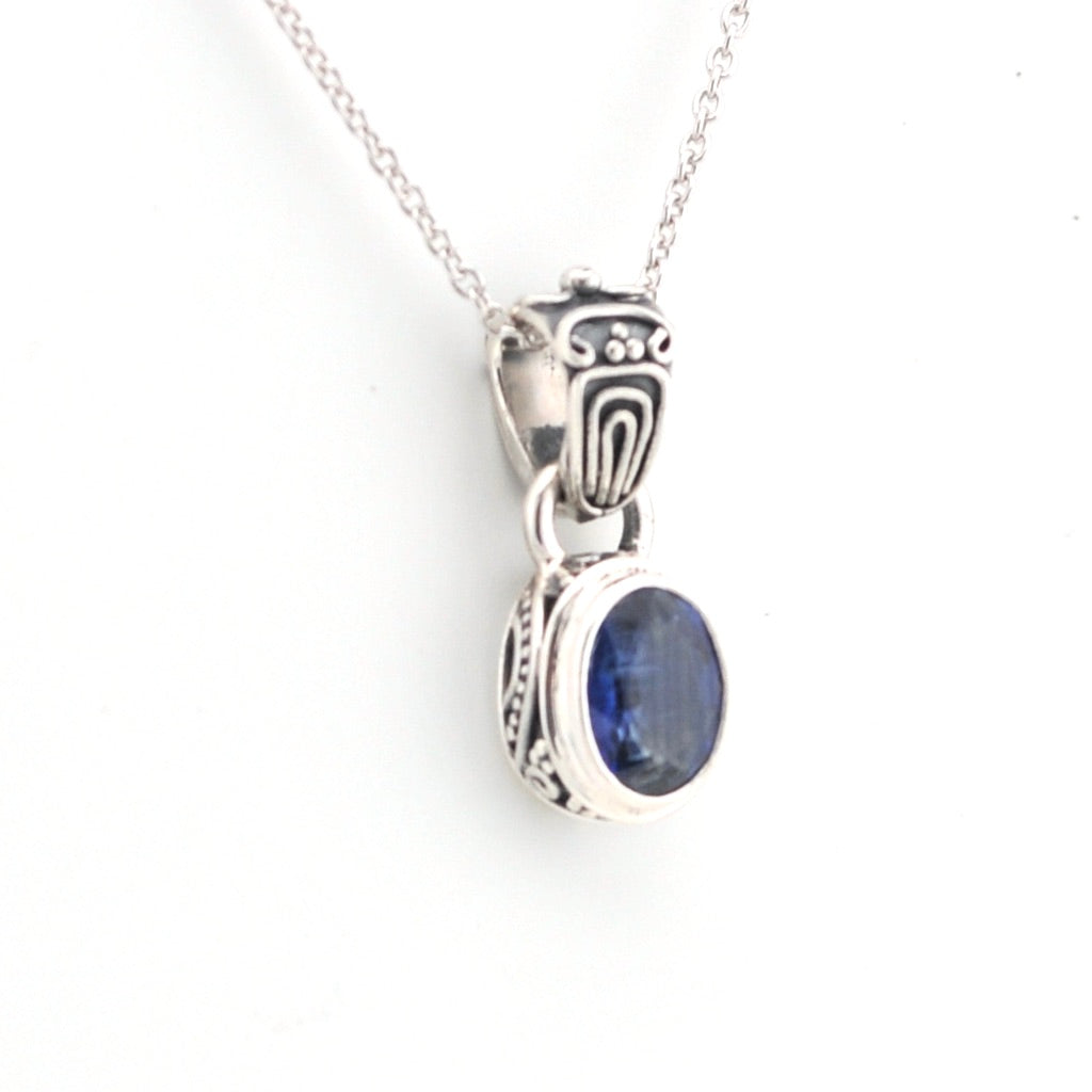 Silver pendant with a blue gemstone on a white background