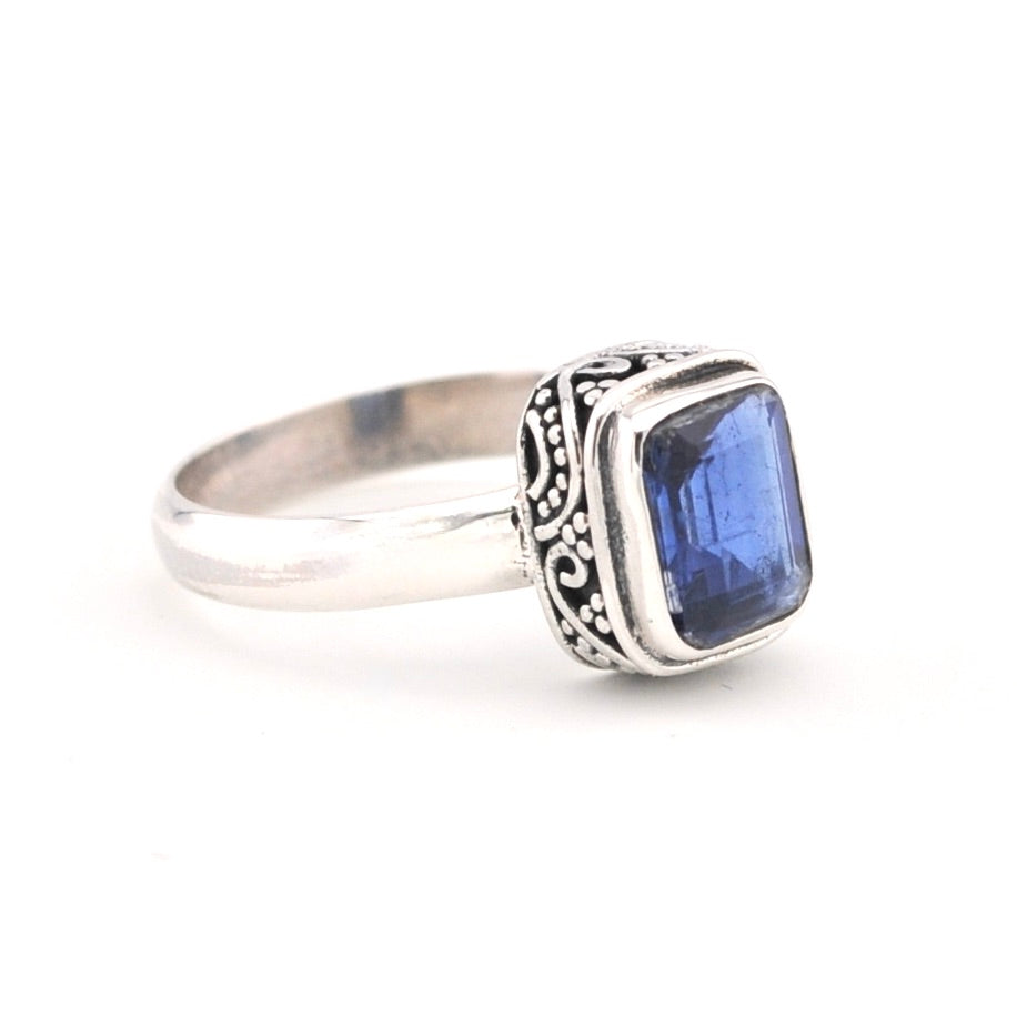 Silver ring with a blue gemstone on a white background