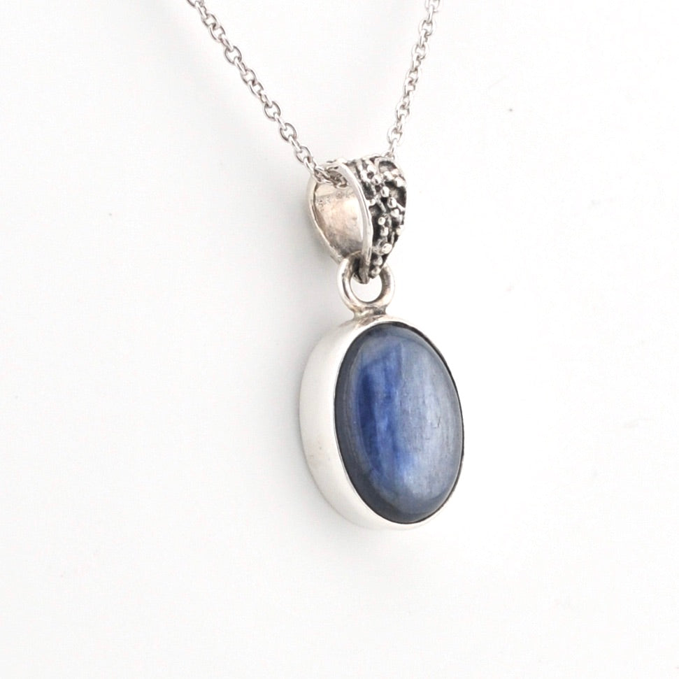 Silver pendant with a blue stone on a white background