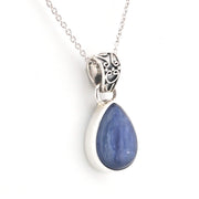 Teardrop-shaped blue pendant on a silver chain against a white background