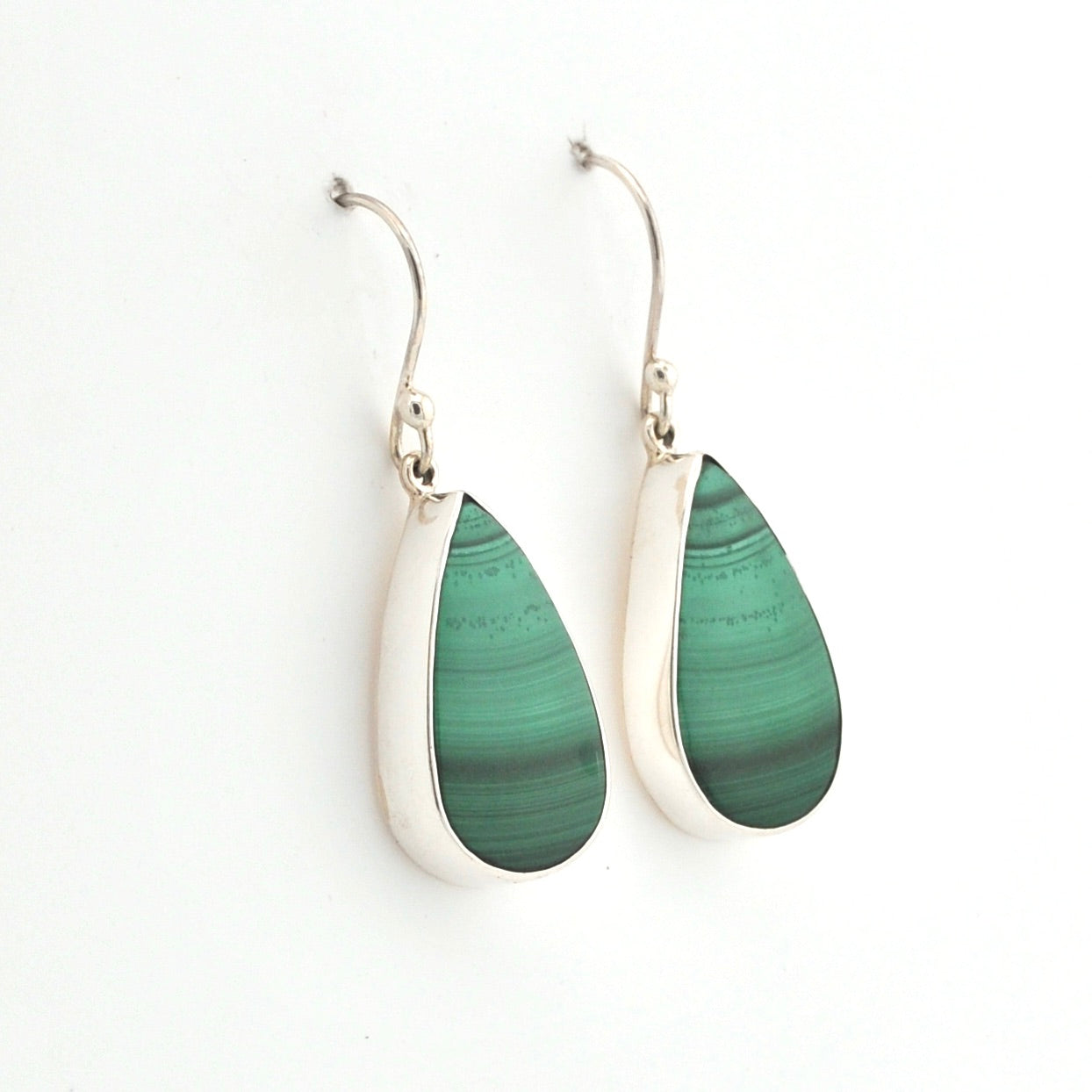 Green teardrop earrings with silver hooks on a white background