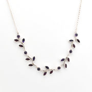 Silver necklace with purple stones on a white background