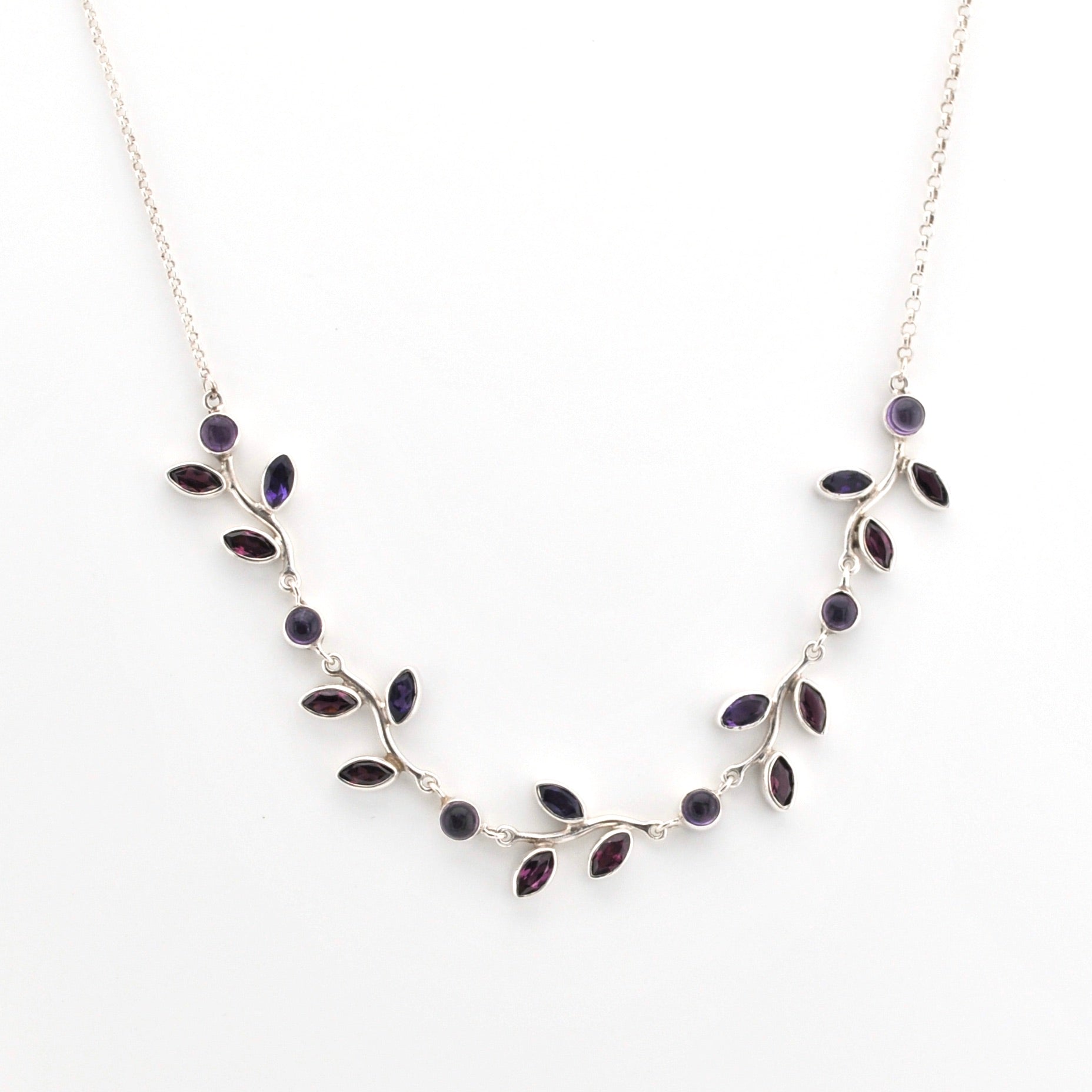 Silver necklace with purple stones on a white background