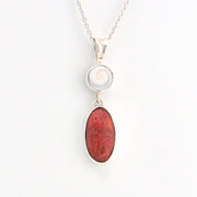 Necklace with a white shell pendant and red stone pendant on a white background