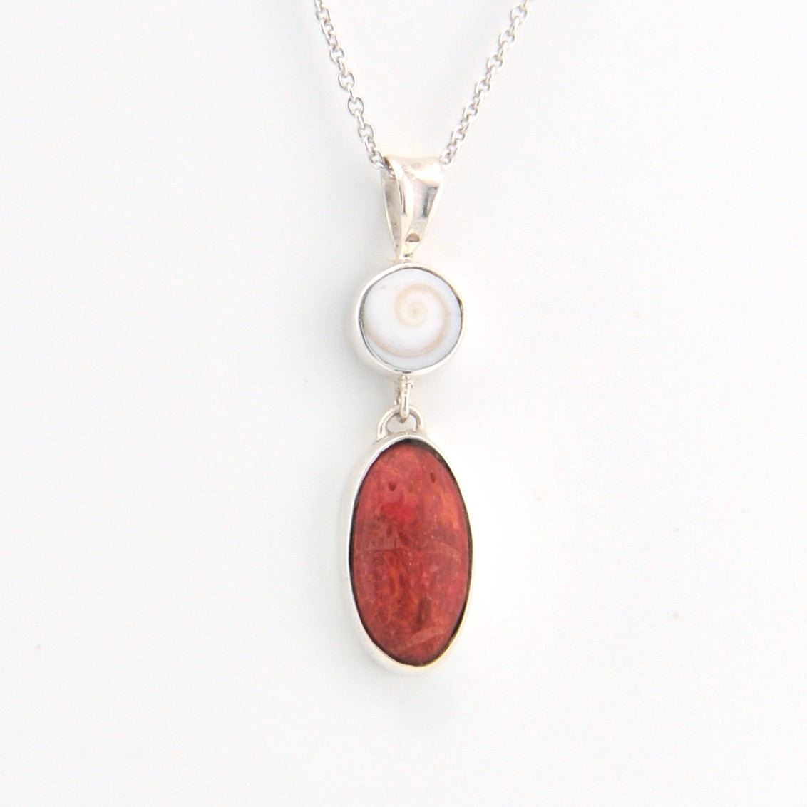 Necklace with a white shell pendant and red stone pendant on a white background
