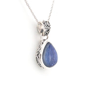 Silver pendant with a blue teardrop-shaped gemstone on a white background