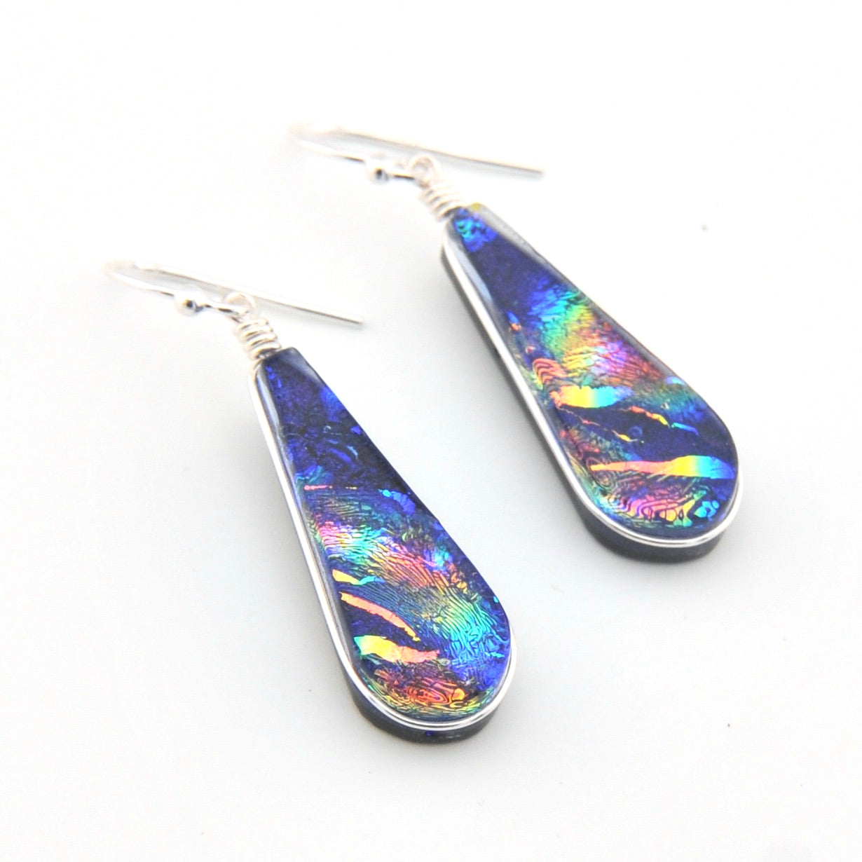 Teardrop-shaped earrings with multicolored iridescent finish on a white background