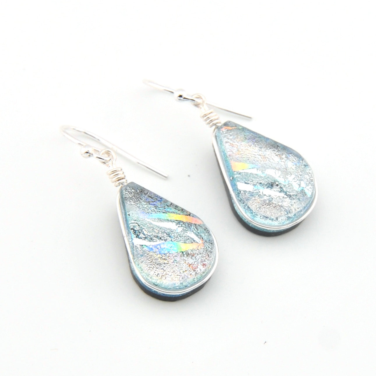 Teardrop-shaped earrings with iridescent finish on a white background
