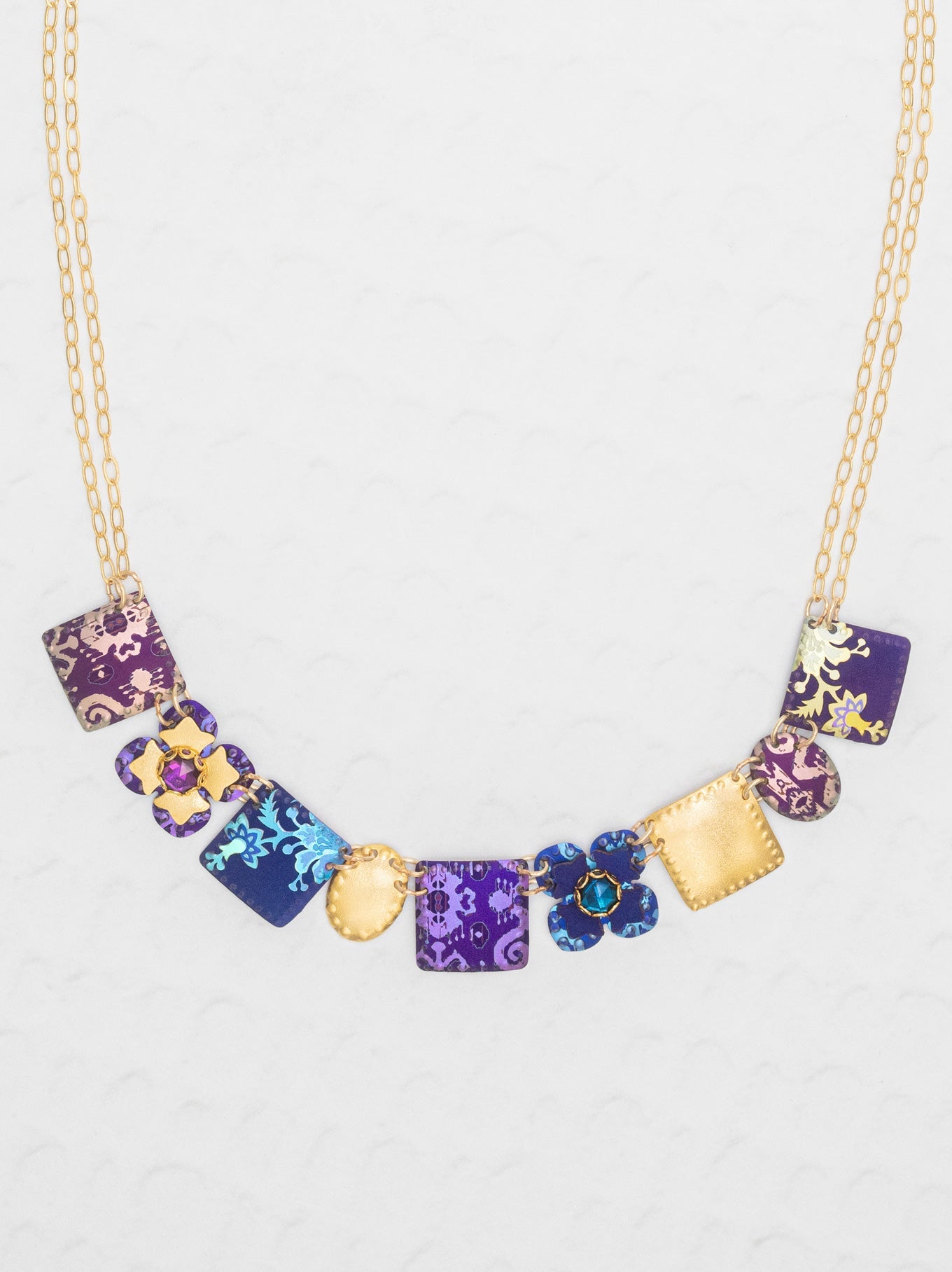 Necklace with colorful square pendants on a light gray background