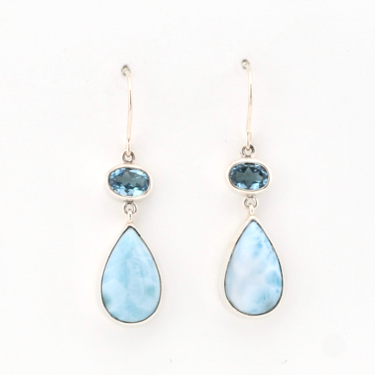 Pair of earrings with teardrop-shaped light blue stones on a white background