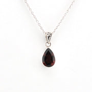 Teardrop-shaped gemstone pendant on a silver chain against a white background