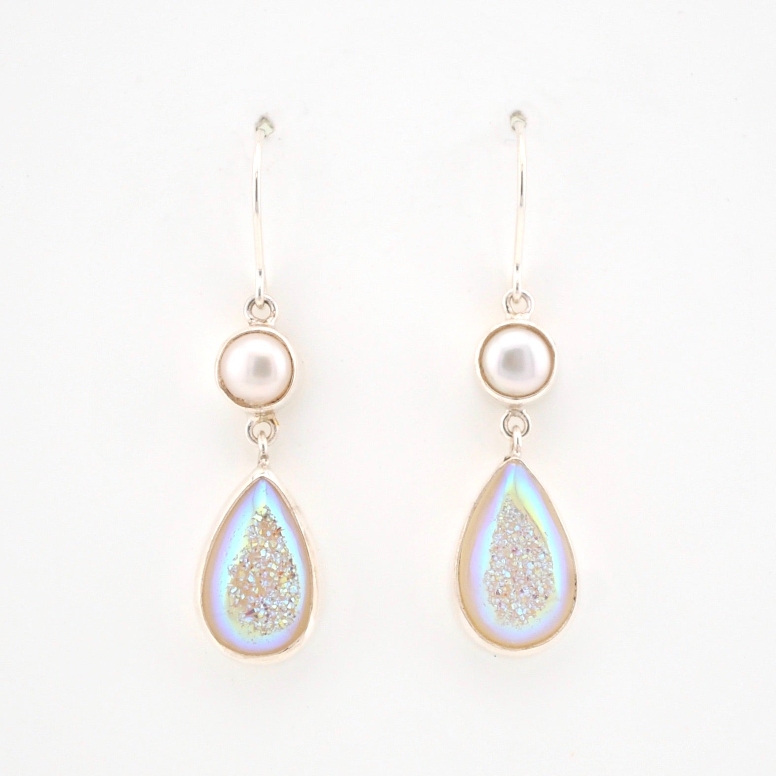 Teardrop-shaped earrings with pearl-like tops on a white background