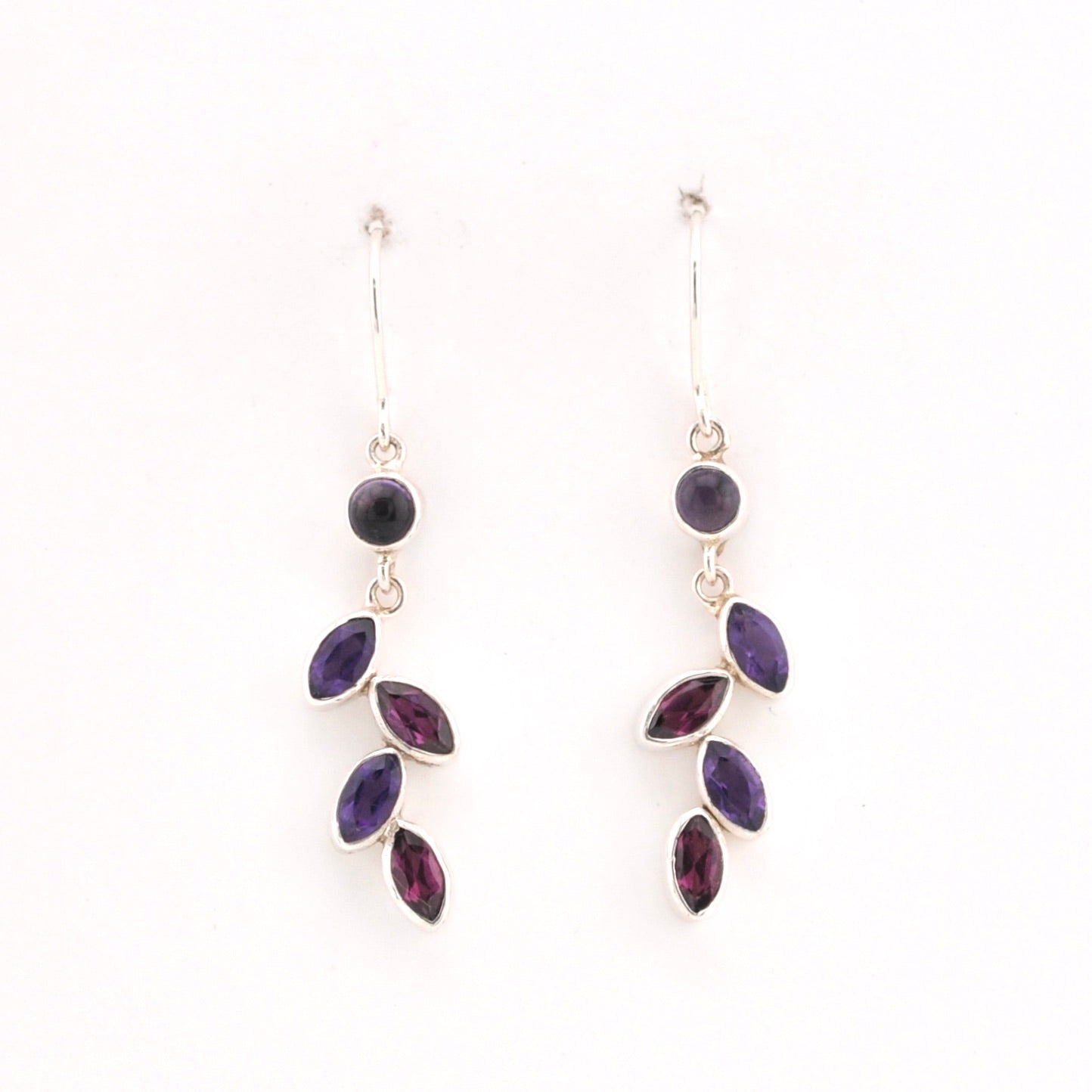 Pair of purple gemstone earrings on a white background